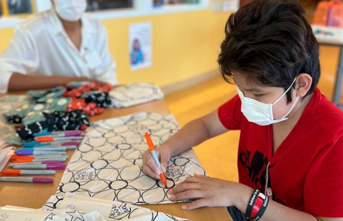 A child colors on paper while receiving treatment at Ann & Robert H. Lurie Children's Hospital of Chicago