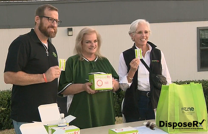 A volunteer, Daniel, Missy Owen, and Ann Hamlin distribute DisposeRx packets to fans as they enter