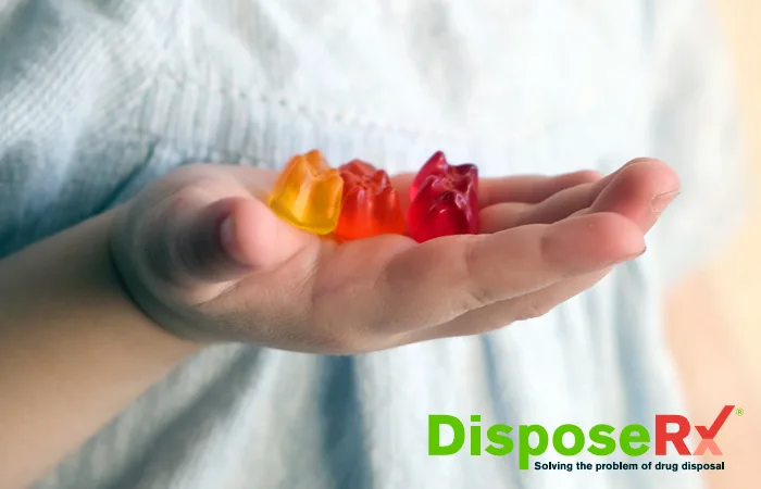 A child's hand holds gummy bears